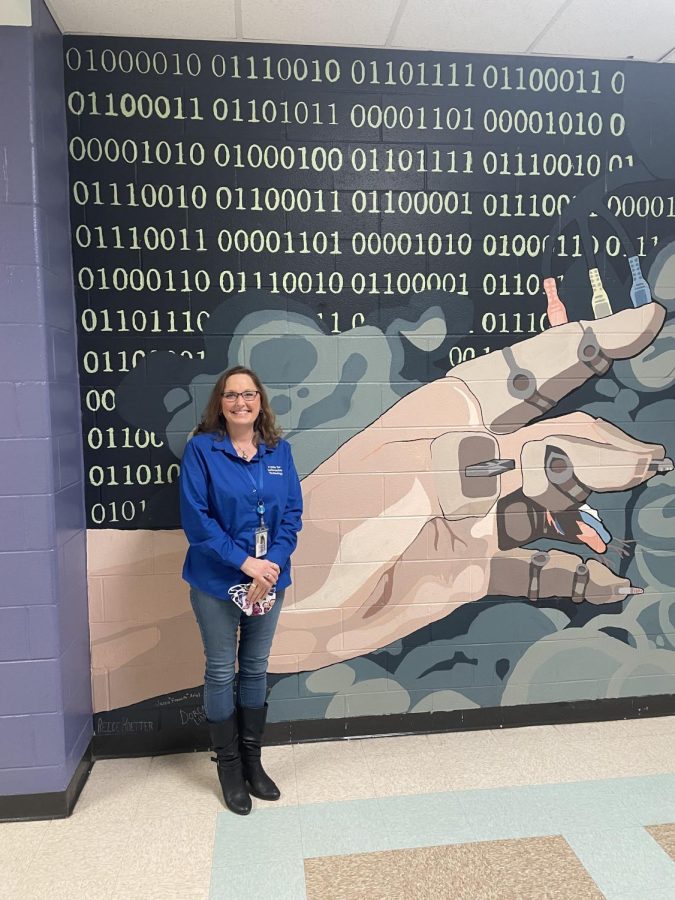 Lynne Norris next to a mural that some of her CIT students painted.