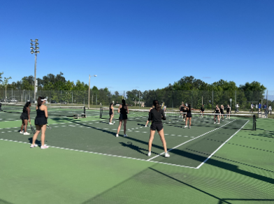The girls tennis team plays a quick game of “tennis volleyball at practice.
