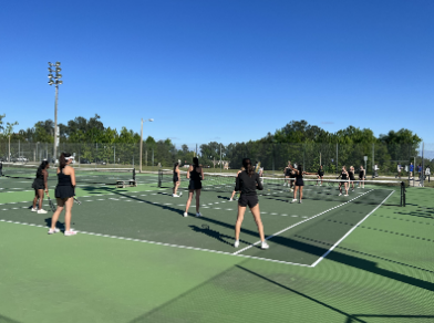 The girls tennis team plays a quick game of “tennis volleyball" at practice.
