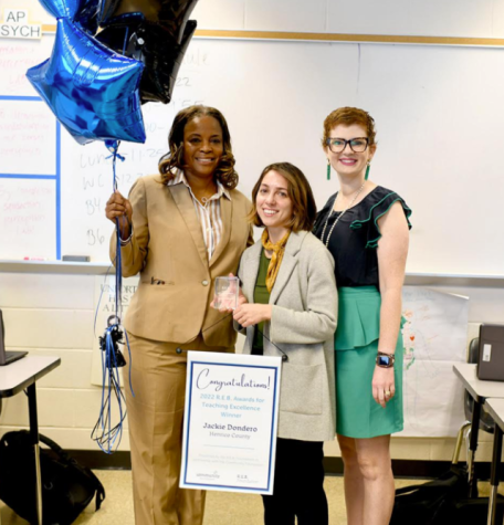 Teacher Jackie Dondero (center) poses with a central office staff member and school board member Marcie Shea (right) as Dondero receives the REB Award in their classroom.
