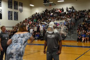 Associate Principal Marcellus Bland is pied by senior Katherine Ogilvie at the end of the pep rally, as assistant principal Angela Steward watches in anticipation of her own turn.