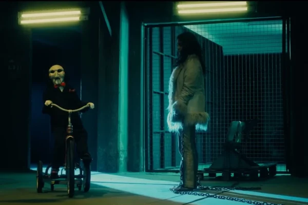 Renata Vaca as Gabriela with Billy the Puppet in Saw X (2023). Photo courtesy of Lionsgate Studios