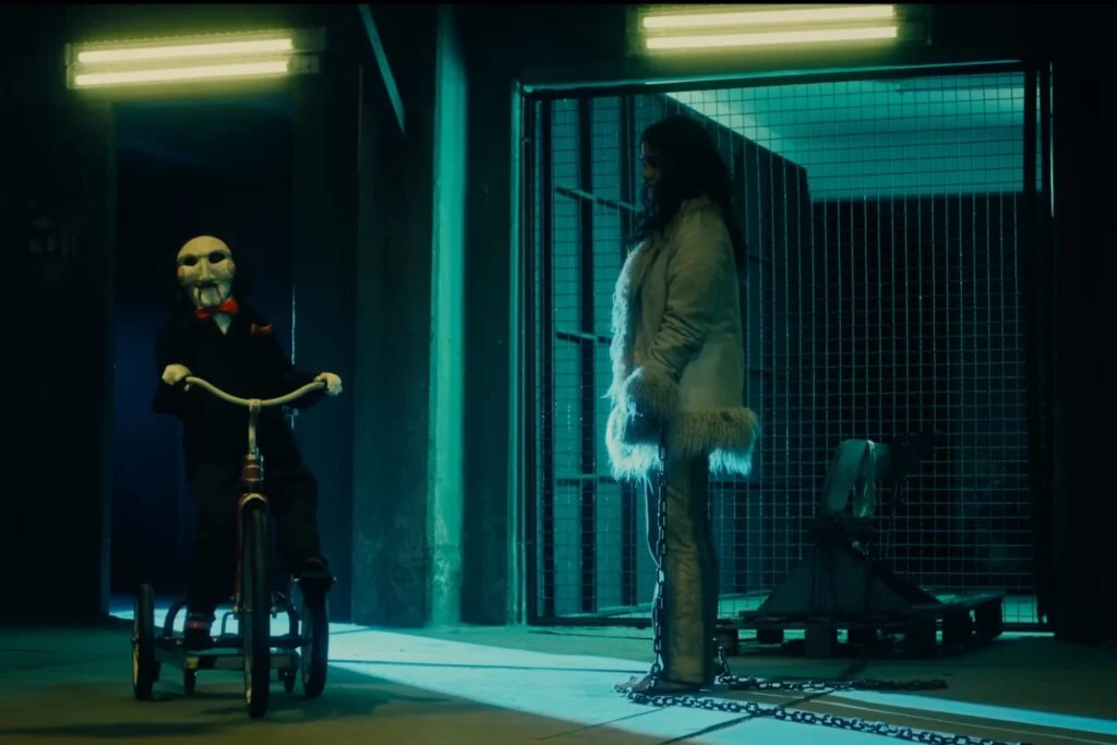 Renata Vaca as Gabriela with Billy the Puppet in Saw X (2023). Photo courtesy of Lionsgate Studios