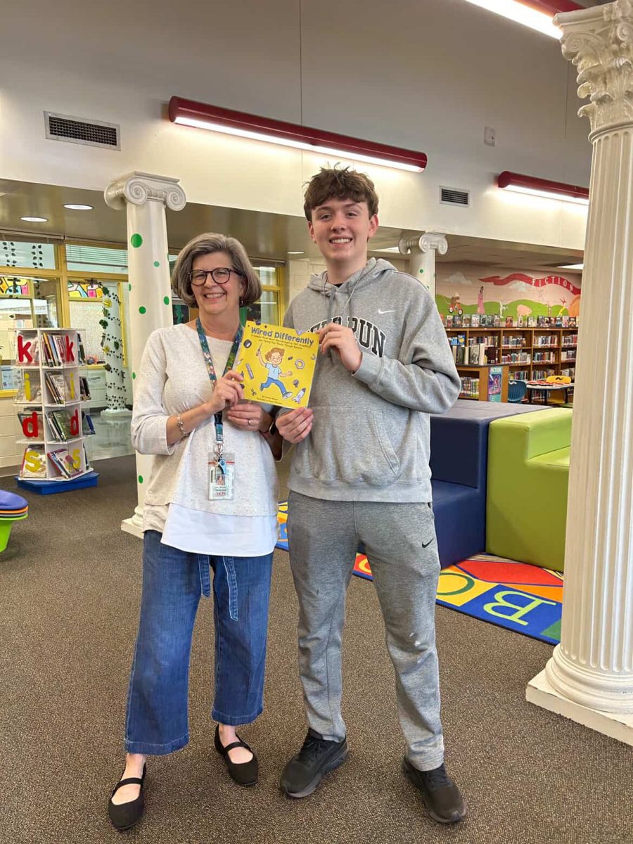 Marek showing off his new book, “Wired Differently,” at John Rolfe Middle School.
